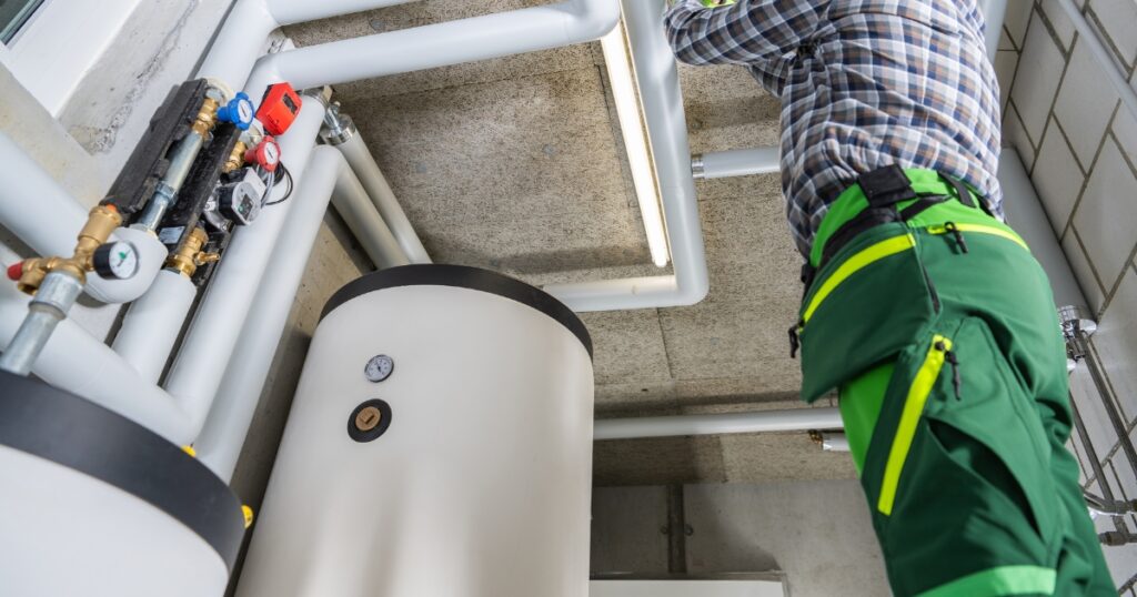 hot water system and a person fixing the pipe above